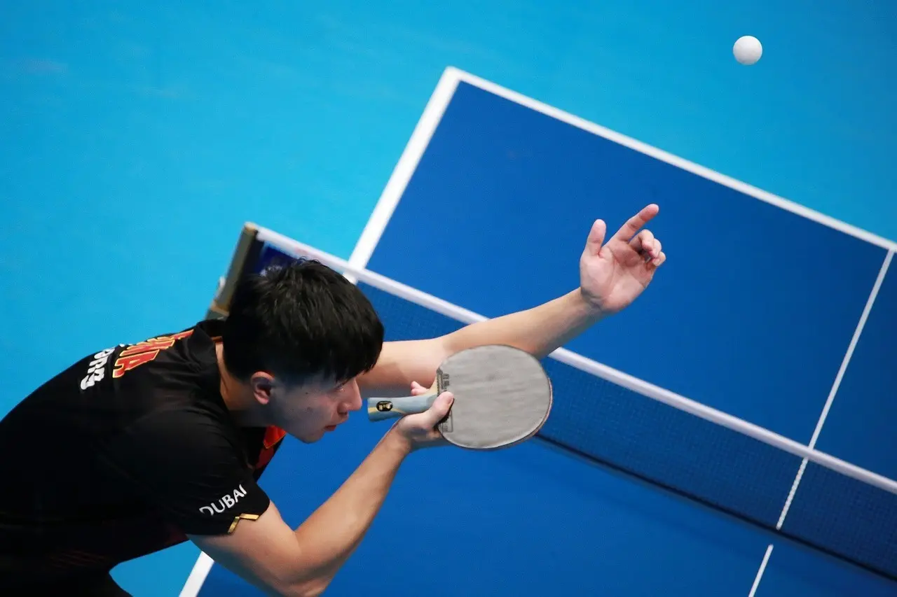 Bordtennisspiller der serverer en bold
